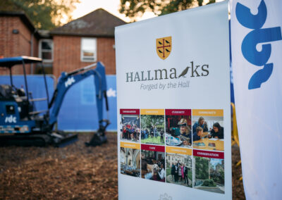 A banner at the groundbreaking ceremony with the words: Hallmarks, Forged by the Hall