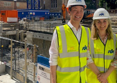 Two people standing in front of the Norham St Edmund construction works