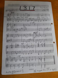 A piece of sheet music arranged by James Harpham for the 1317 Challenge as part of Community and Giving Week. The piece is titled 1317 and is written with 13 17 notation.