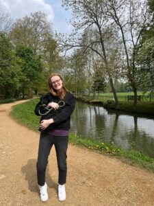 A picture of Lydia Smith at Christchurch Meadow carrying her puppy in a bag.